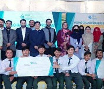 Students and mentors from the Young Changemakers Program holding award cheques